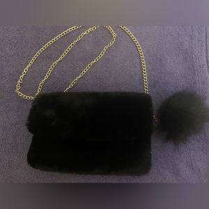 Faux fur black evening bag with Pom Pom and gold chain.